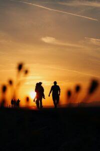 Couple marchant sur les Planches de Deauville au coucher du soleil.